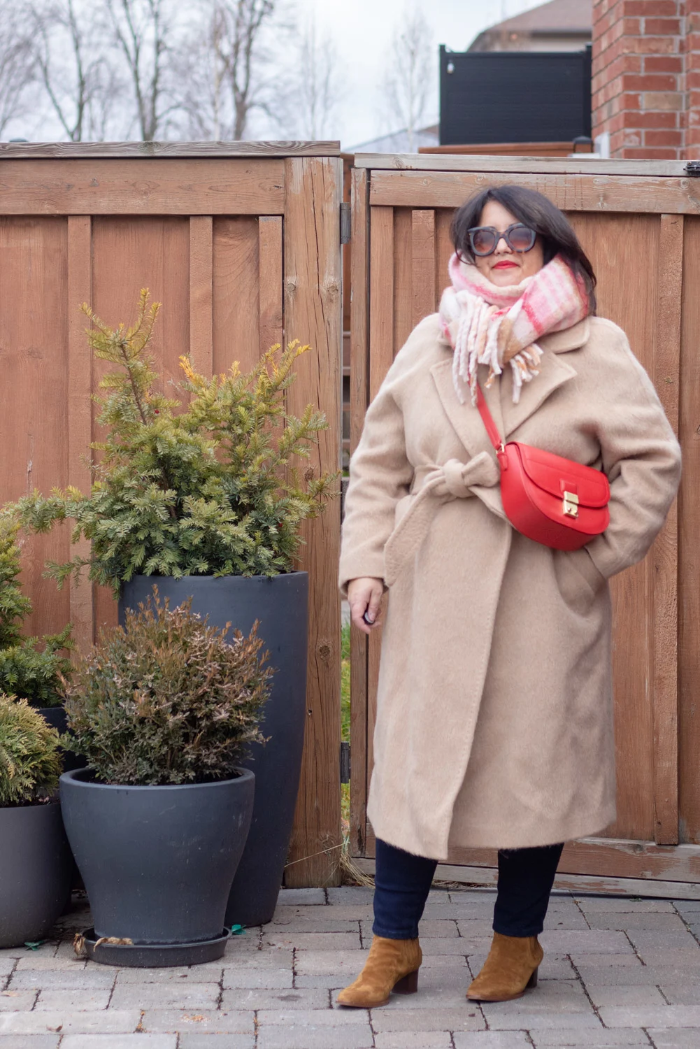 camel coat, red bag