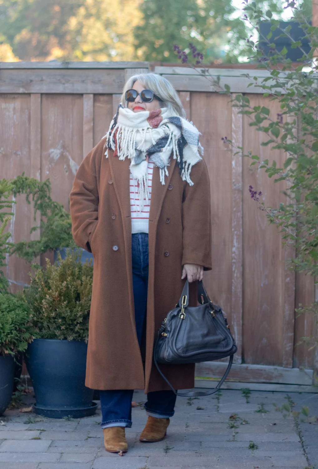 dark camel slouch coat aritzia, straight leg denim, stripe sezane sweater