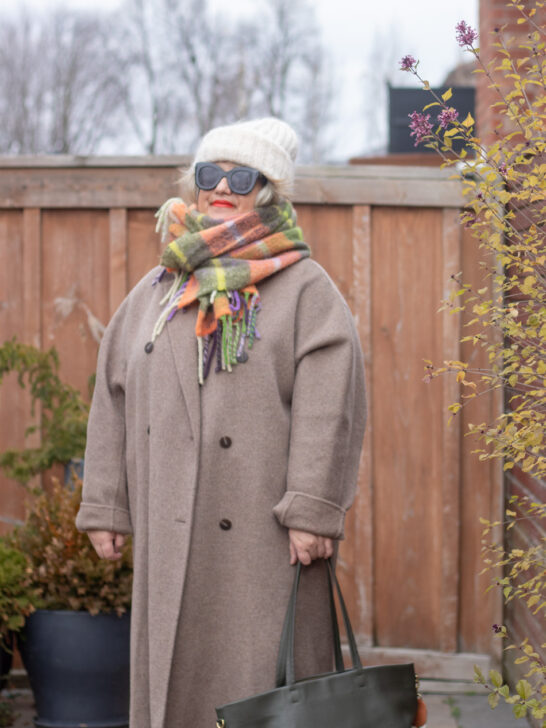 greige coat with soft hued accessories and green