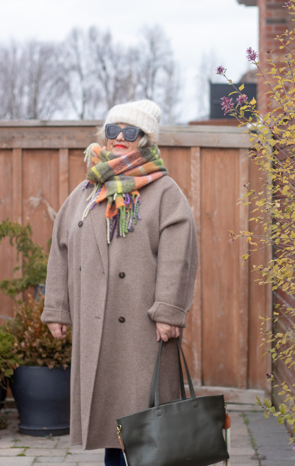 greige coat with soft hued accessories and green